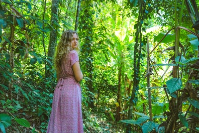 穿着紫色的女孩站在森林白天
